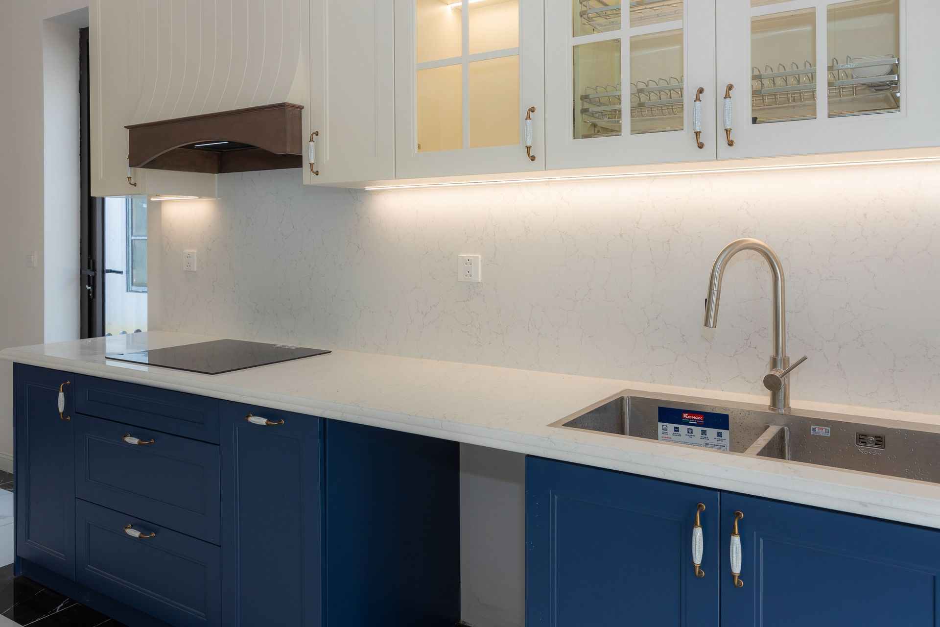 Sleek kitchen featuring blue cabinets, white countertops, and modern fixtures.